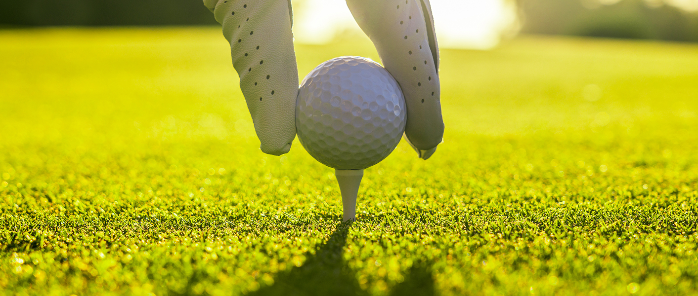 hand placing golf ball on tee