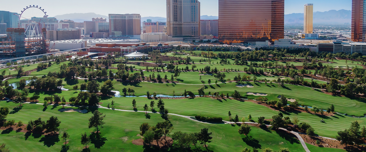 arial shot of golf course with buildings in background