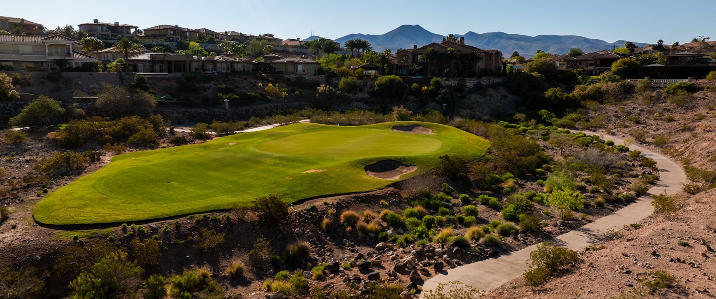arial shot of golf course with buildings in background