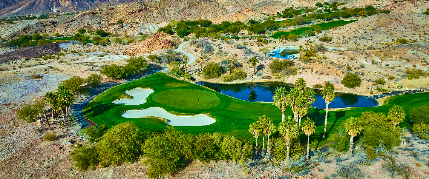 arial shot of golf course with buildings in background