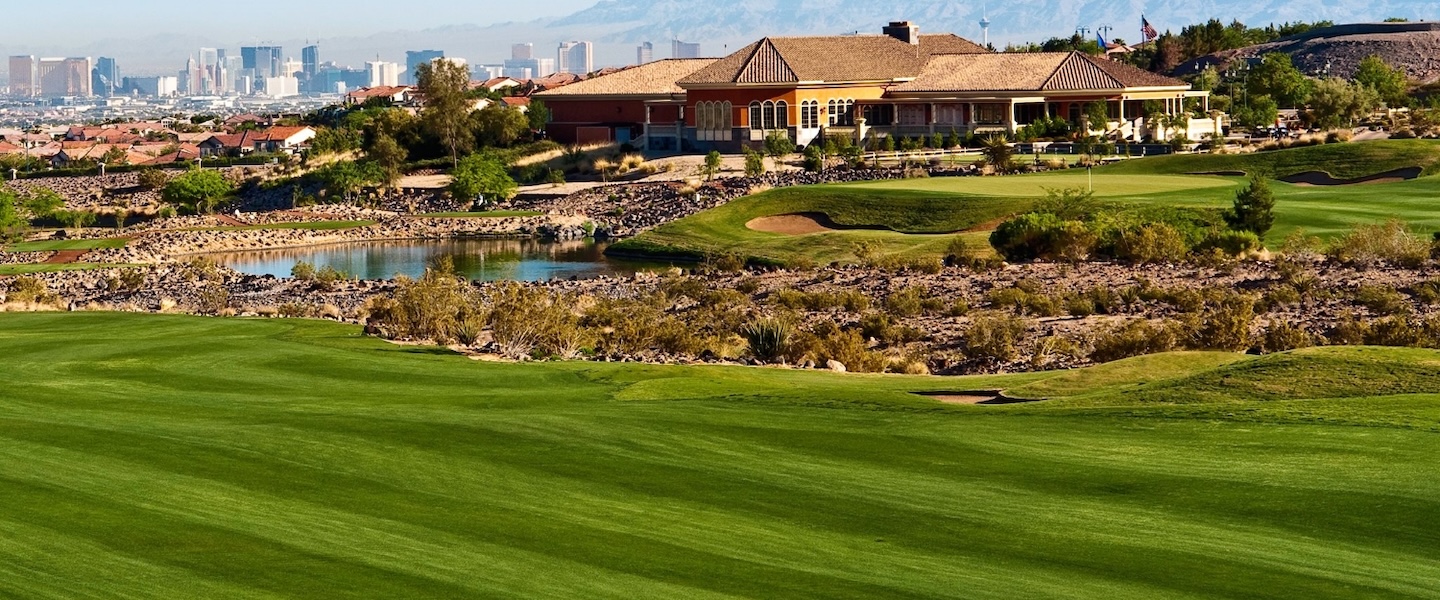 arial shot of golf course with buildings in background